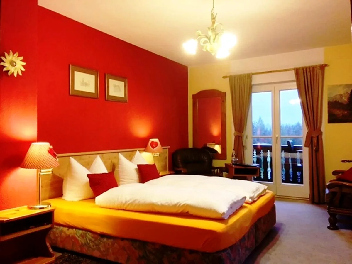 Doppelzimmer mit roter Wand, Doppelbett und Balkontür
